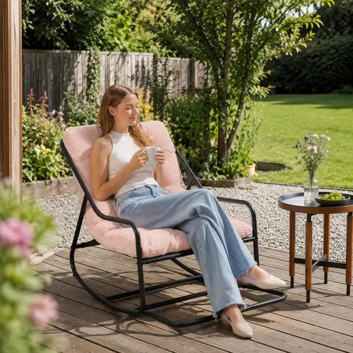 Fauteuil à bascule de jardin Belle Étoile, coussin rose et structure en acier noir, sur une terrasse