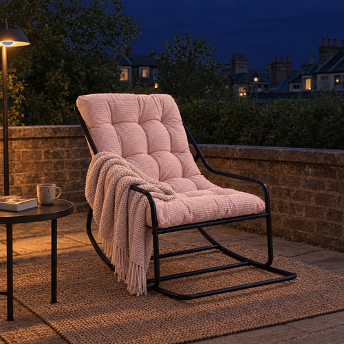 Fauteuil à bascule BELLE ÉTOILE avec coussin rose pâle en velours côtelé, sur une terrasse le soir